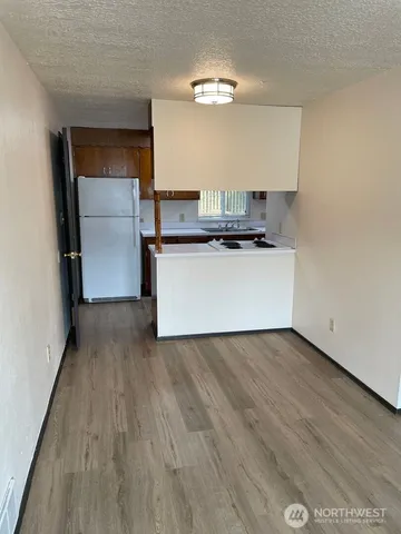 a kitchen with a refrigerator and a stove top oven