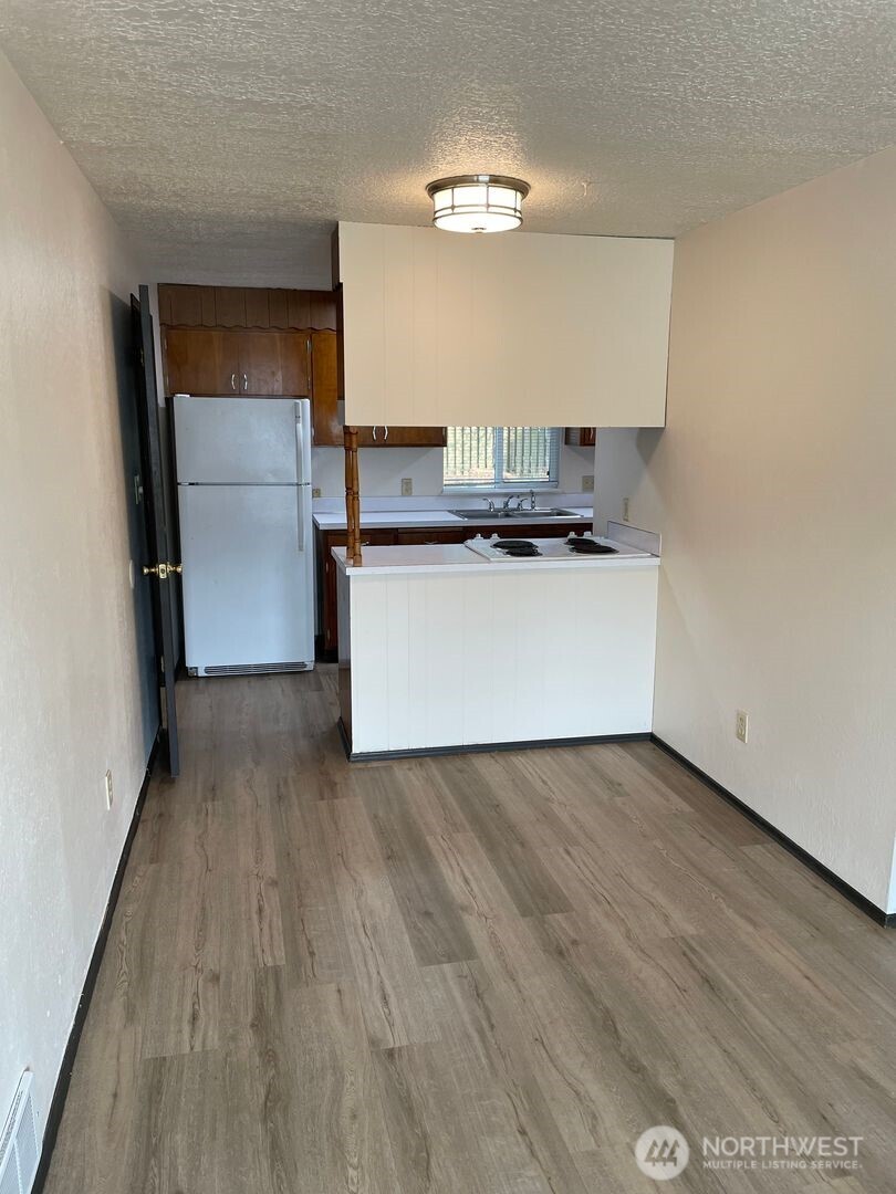 13317 28th Street Northeast, Unit A/B Lake Stevens, WA 98258 - Photo 3 of 14 a kitchen with a refrigerator and a stove top oven