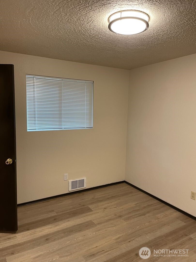 13317 28th Street Northeast, Unit A/B Lake Stevens, WA 98258 - Photo 5 of 14 an empty room with wooden floor and windows