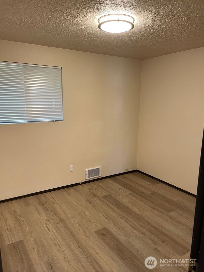 13317 28th Street Northeast, Unit A/B Lake Stevens, WA 98258 - Photo 10 of 14 an empty room with wooden floor and windows
