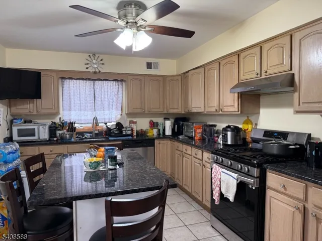 a kitchen with stainless steel appliances granite countertop a stove sink refrigerator and cabinets