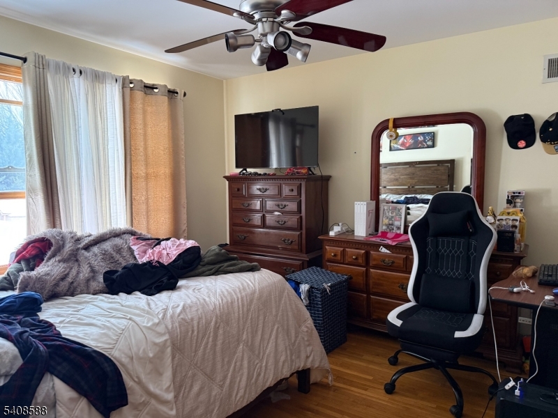 76 Passaic Avenue, Unit 76 Nutley, NJ 07110 - Photo 8 of 15 a bedroom with a bed and wooden floor