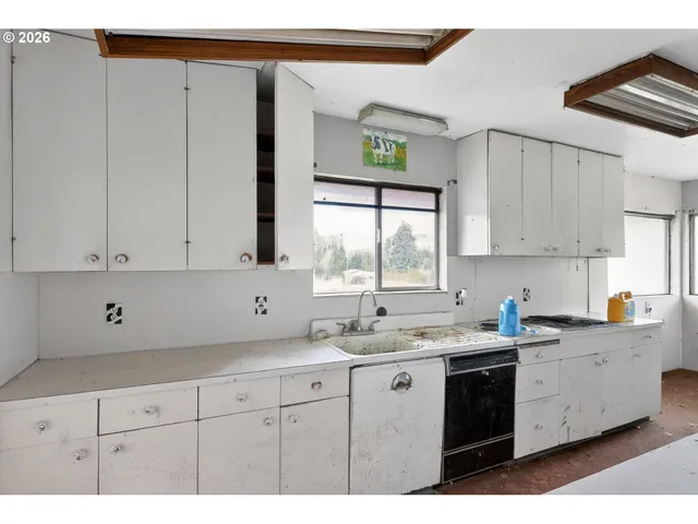 a kitchen with a sink window and cabinets