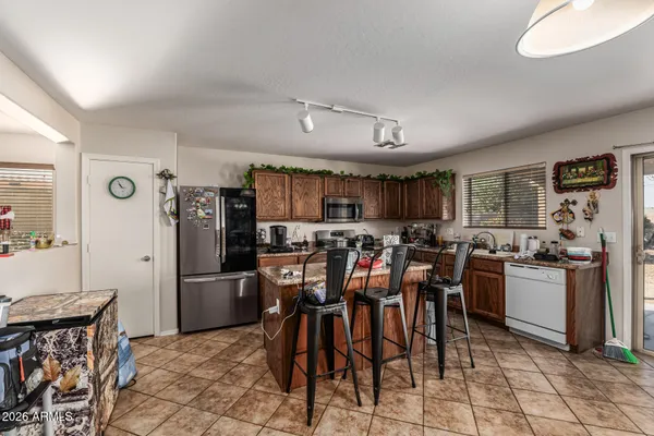 a kitchen with stainless steel appliances kitchen island granite countertop a refrigerator and a stove top oven