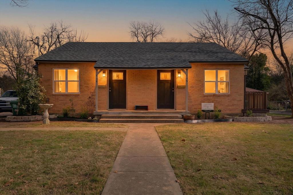 Bungalow with a porch, a front lawn, brick siding, and a shingled roof