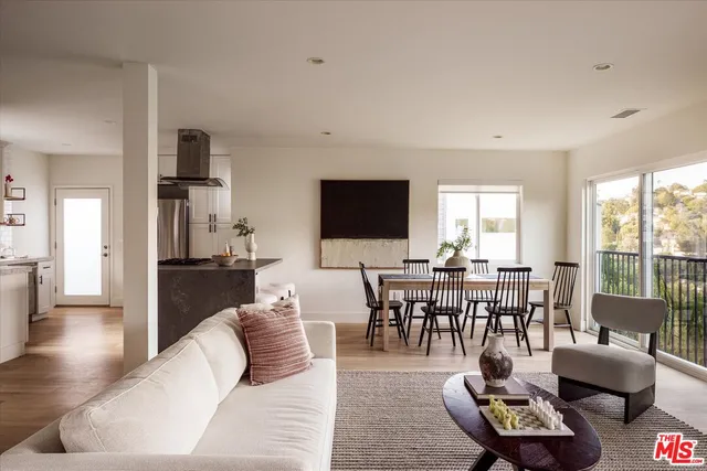 a living room with furniture a rug a flat screen tv and a large window
