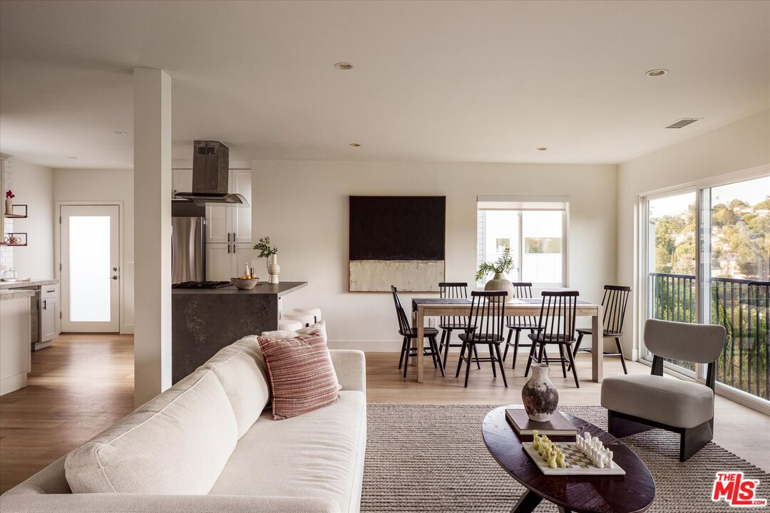a living room with furniture a rug a flat screen tv and a large window