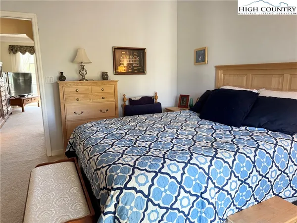 a bedroom with a bed and a lamp on dresser