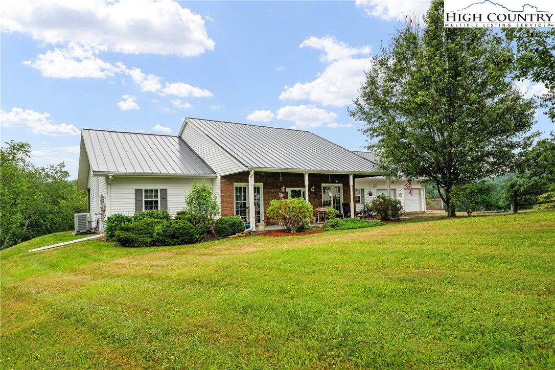 175 Olive Ridge Drive Crumpler, NC 28617 - Photo 50 of 50 a front view of a house with a garden and trees