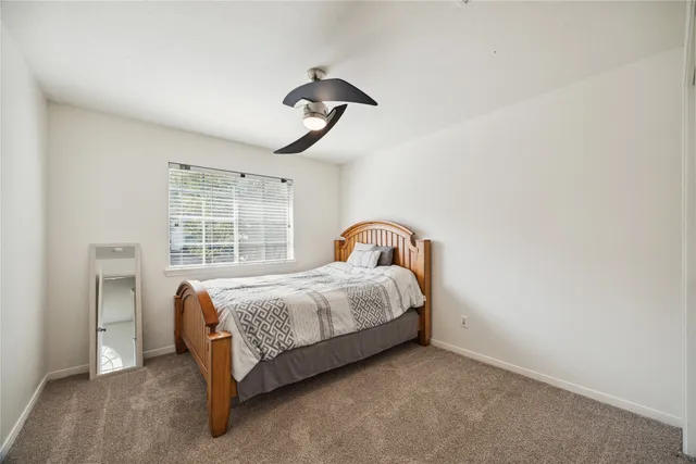 a bed sitting in a bedroom next to a window and a chandelier