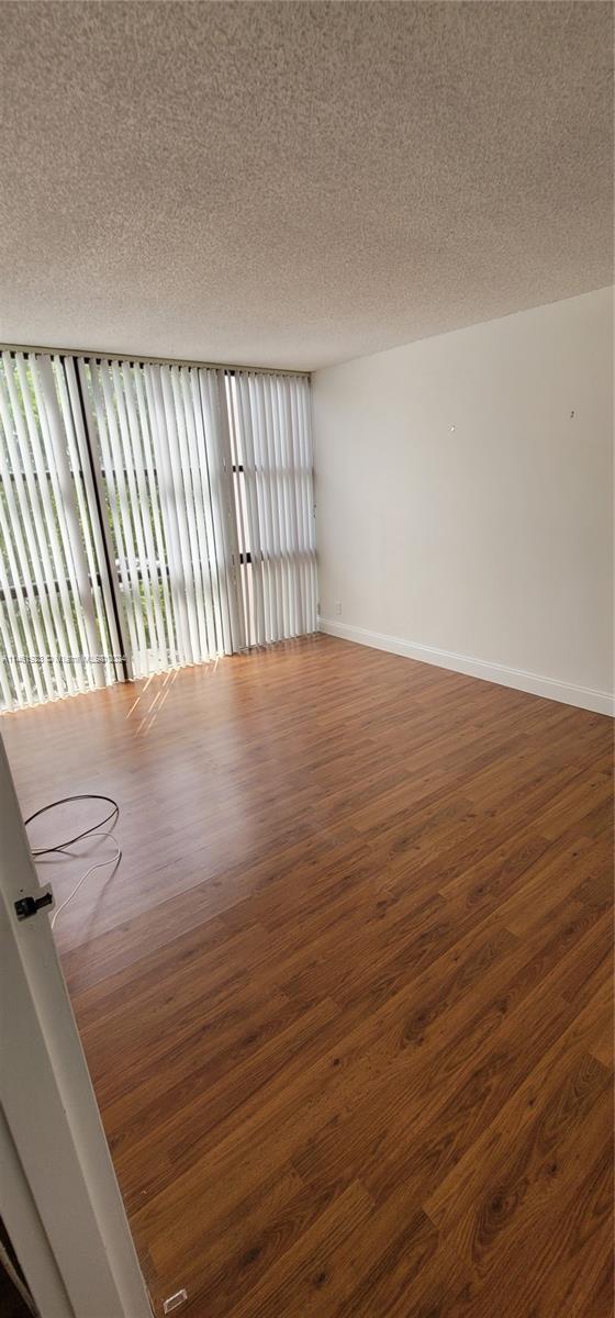 17021 North Bay Road, Unit 516 Sunny Isles Beach, FL 33160 - Photo 6 of 10 a view of an empty room with wooden floor