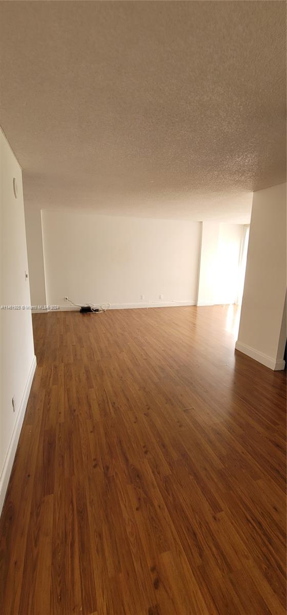 17021 North Bay Road, Unit 516 Sunny Isles Beach, FL 33160 - Photo 7 of 10 an empty room with wooden floor and windows