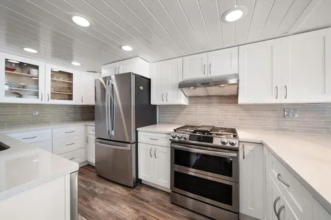 a kitchen with stainless steel appliances a stove a sink and a refrigerator