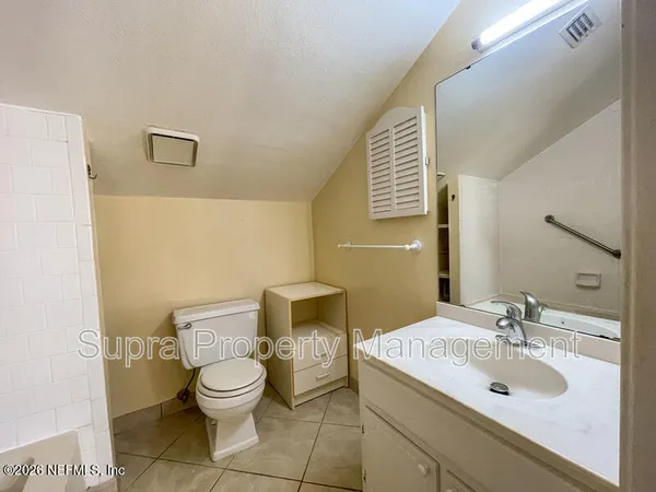 a bathroom with a granite countertop bathtub and a toilet