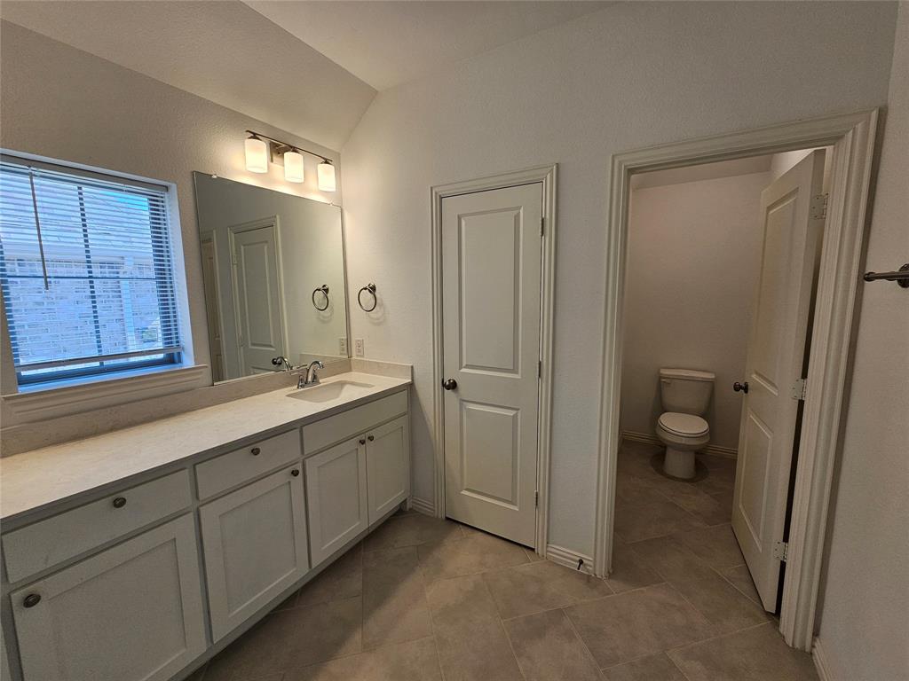 7280 Panicum Drive Frisco, TX 75033 - Photo 23 of 36 a bathroom with a double vanity sink a toilet and a shower