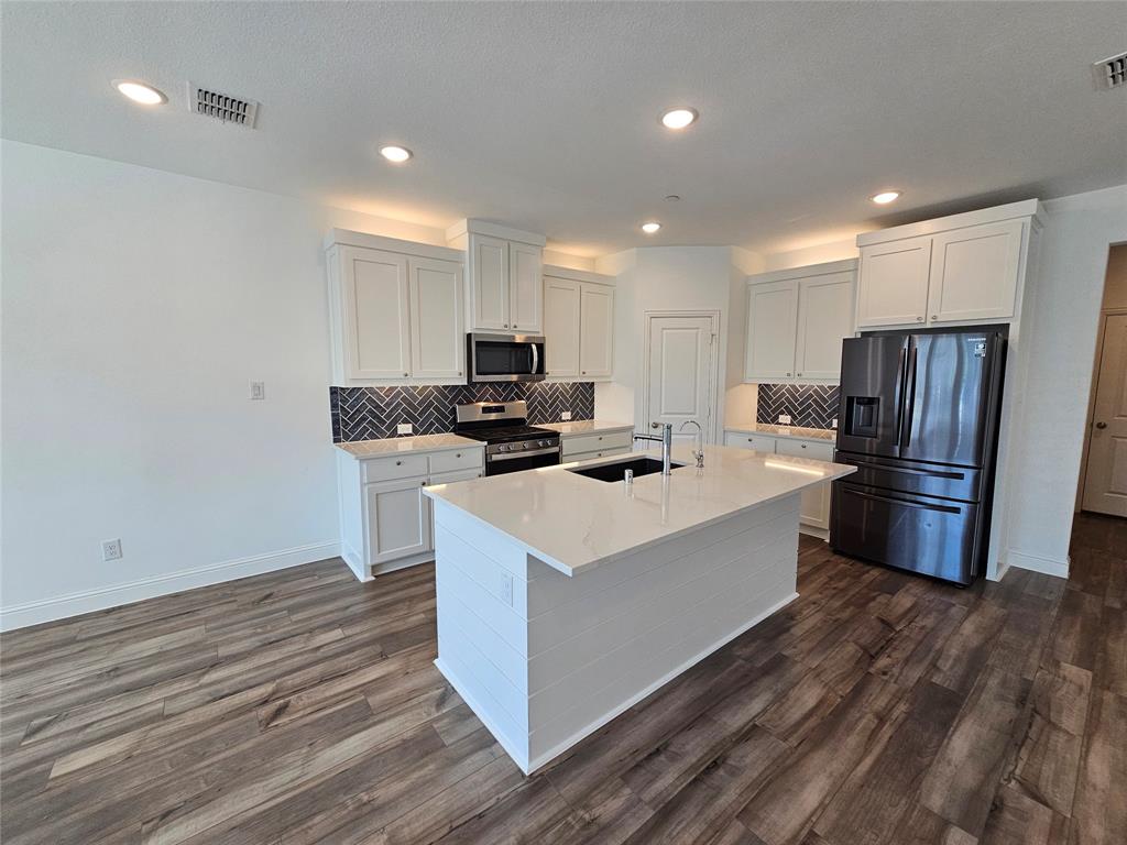 7280 Panicum Drive Frisco, TX 75033 - Photo 8 of 36 a kitchen with stainless steel appliances a refrigerator a stove a sink and a microwave