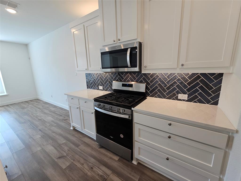 7280 Panicum Drive Frisco, TX 75033 - Photo 9 of 36 a kitchen with a stove and a microwave