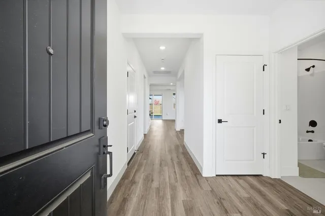a view of a hallway with wooden floor