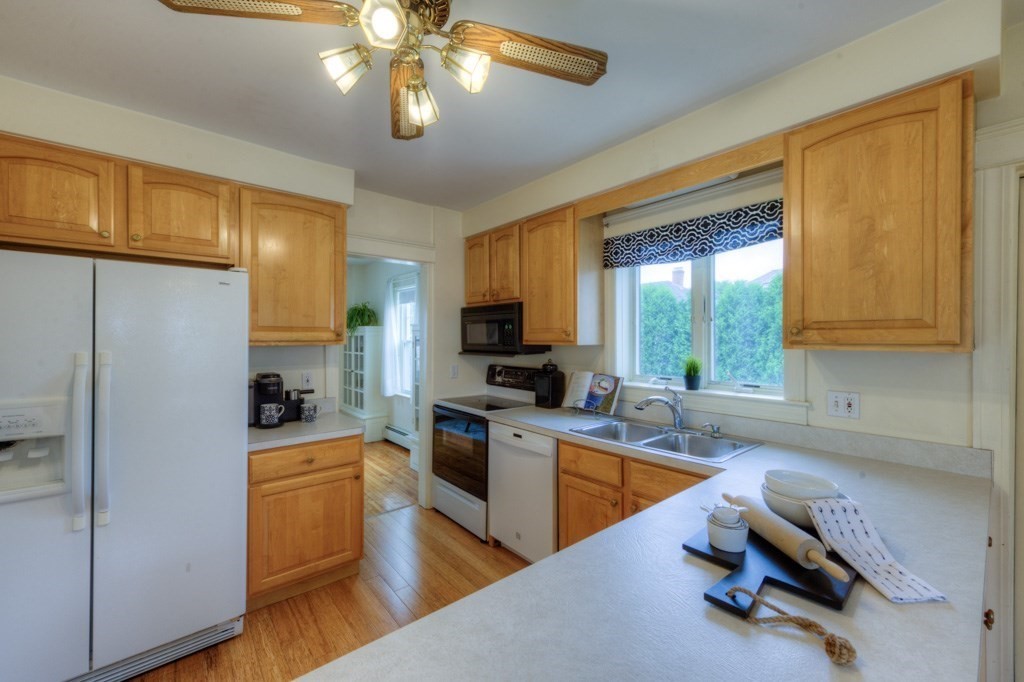 5 Bellingham Road Worcester, MA 01606 - Photo 10 of 30 a kitchen with stainless steel appliances granite countertop a refrigerator a sink dishwasher a stove and a dining table with wooden floor