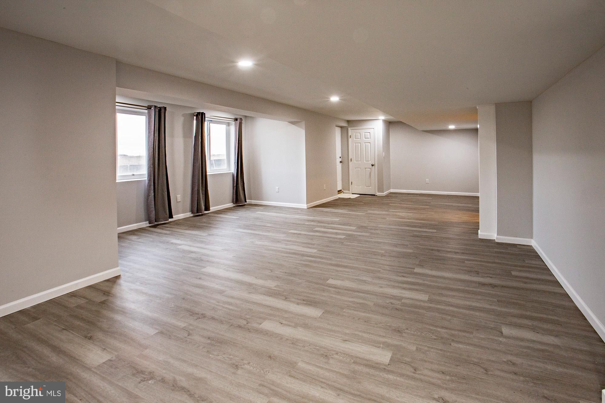 653 Gordon House Way Middletown, DE 19709 - Photo 2 of 7 a view of an empty room with wooden floor and a window