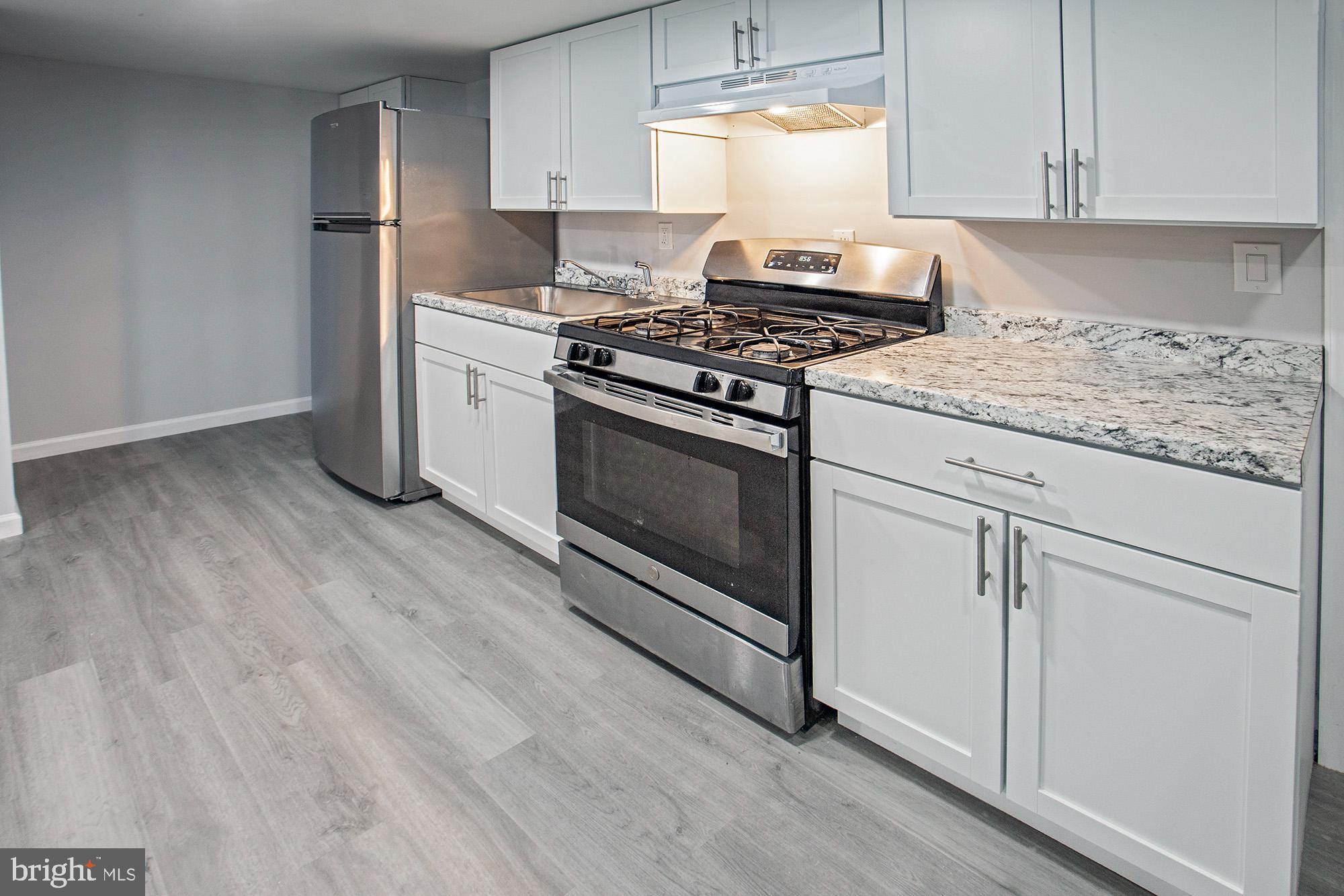 653 Gordon House Way Middletown, DE 19709 - Photo 3 of 7 a kitchen with granite countertop cabinets stainless steel appliances and wooden floor