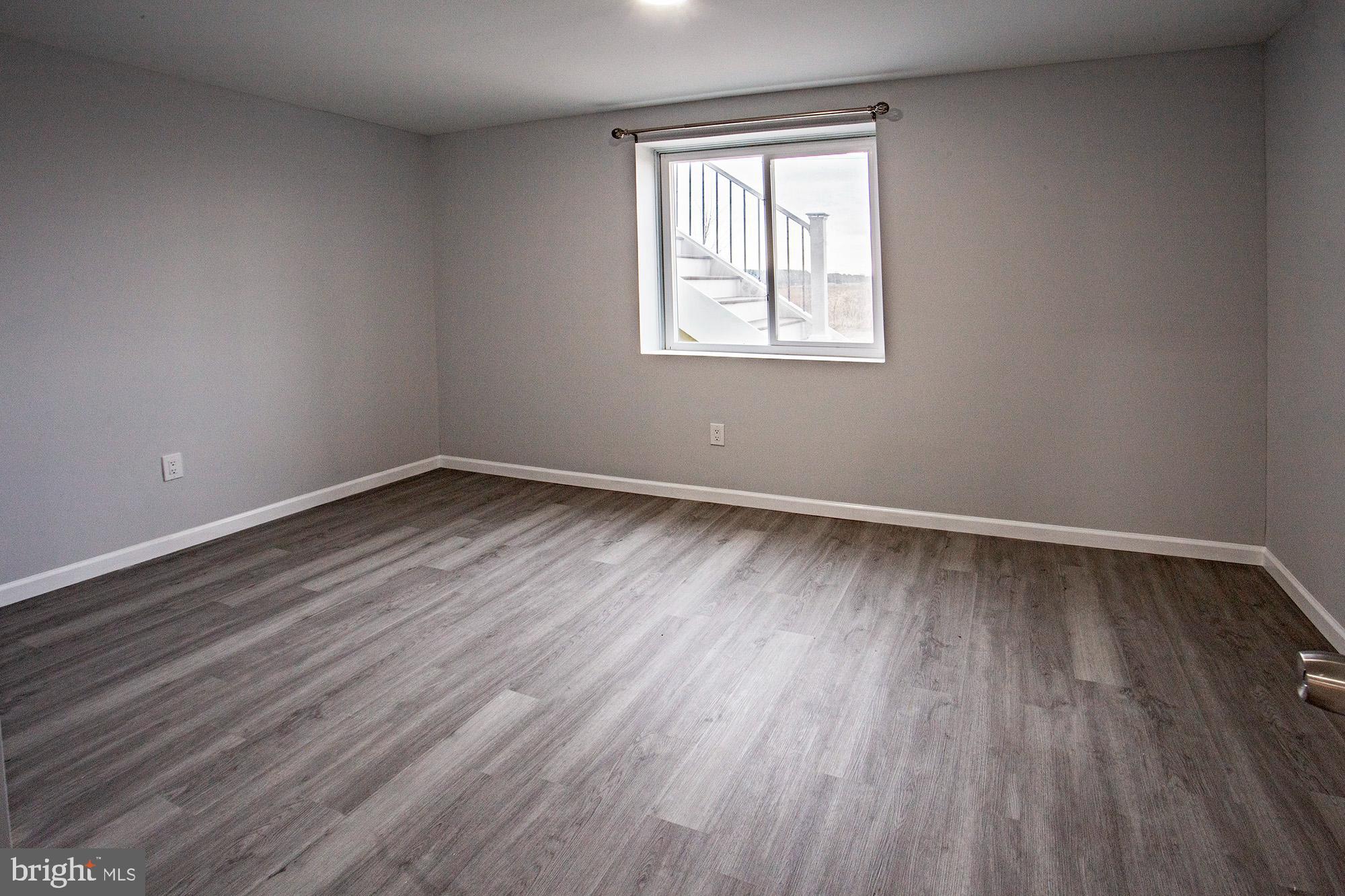 653 Gordon House Way Middletown, DE 19709 - Photo 4 of 7 a view of an empty room with wooden floor and a window