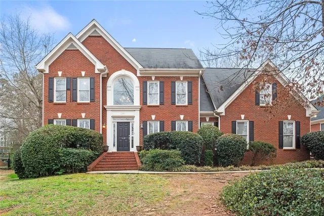 a front view of a house with yard and green space
