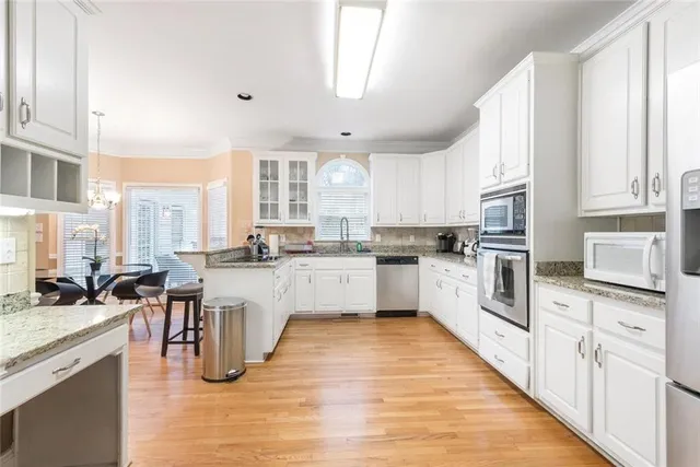a kitchen with white cabinets sink and appliances