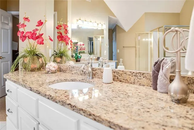 a bathroom with a granite countertop sink and a mirror