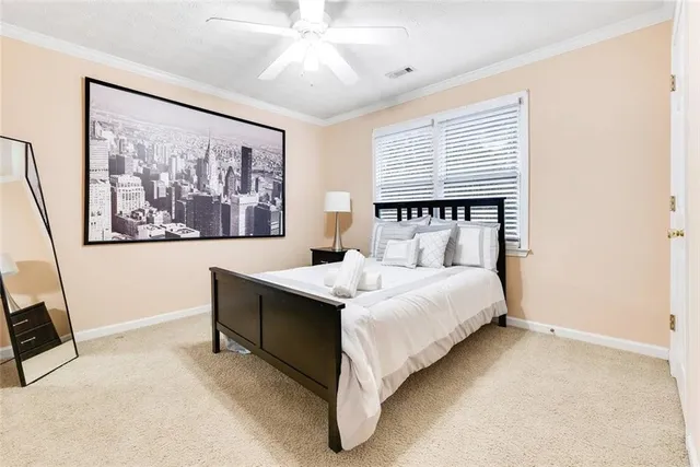 a bed sitting in a spacious bedroom next to a window