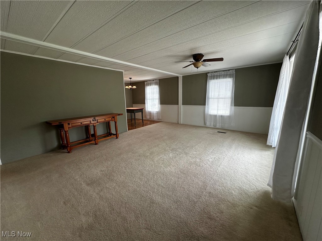 12921 Springfield Road, Unit 12S New Springfield, OH 44443 - Photo 22 of 25 Carpeted empty room with ceiling fan with notable chandelier