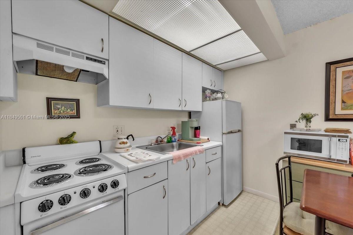 13455 Southwest 16th Court, Unit 104F Pembroke Pines, FL 33027 - Photo 11 of 53 a kitchen with stainless steel appliances a stove a sink and a refrigerator