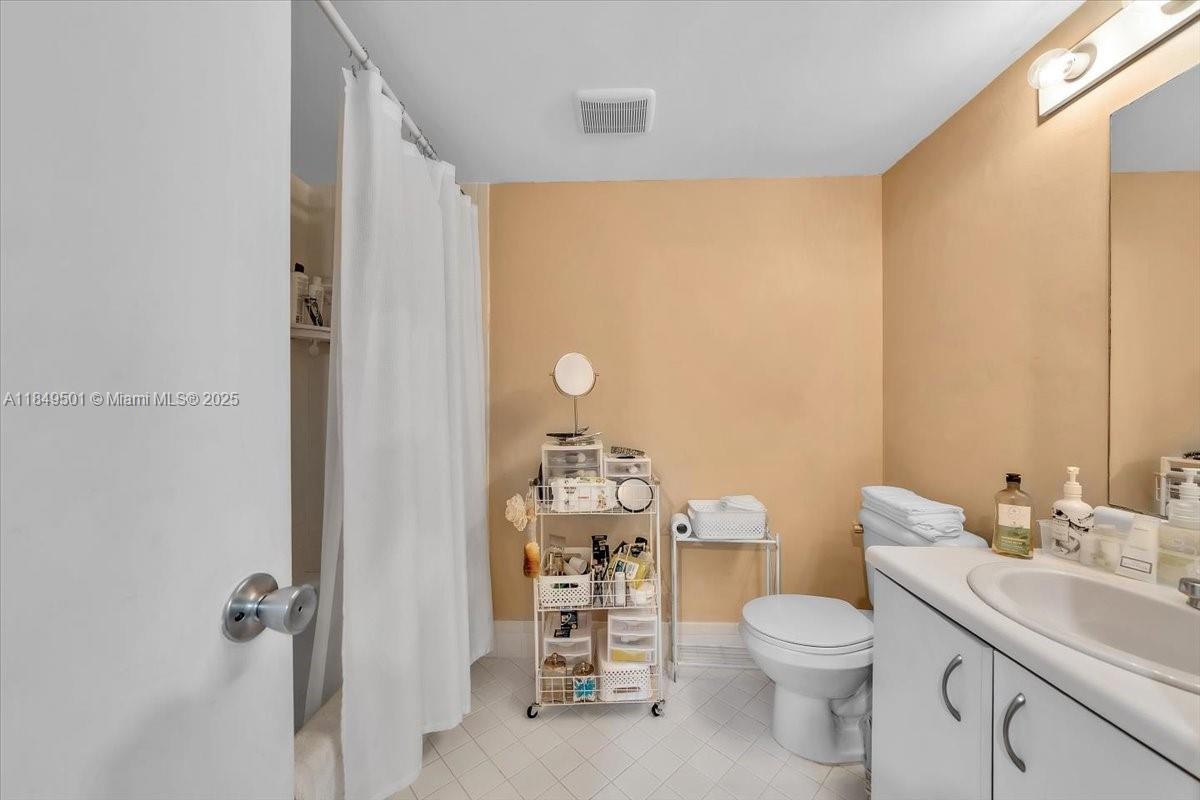 13455 Southwest 16th Court, Unit 104F Pembroke Pines, FL 33027 - Photo 14 of 53 a bathroom with a toilet a sink and a mirror