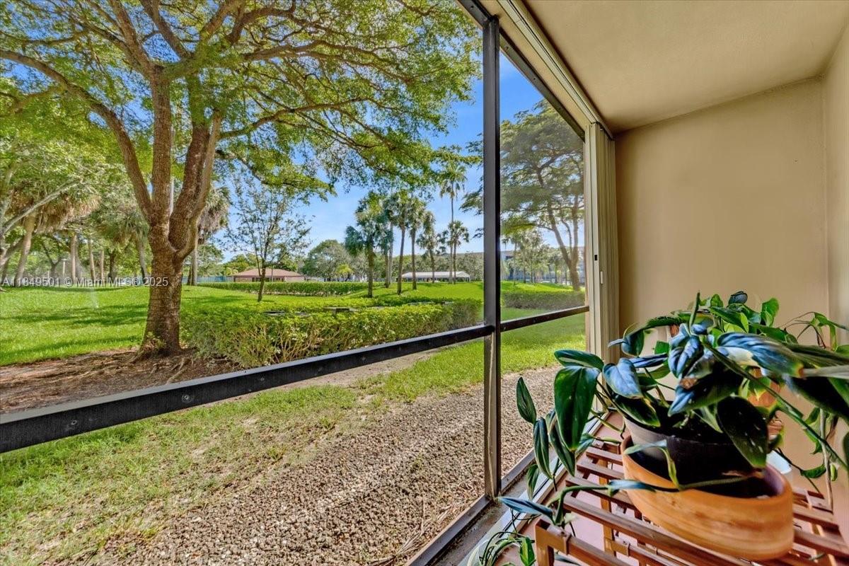 13455 Southwest 16th Court, Unit 104F Pembroke Pines, FL 33027 - Photo 18 of 53 a view of a floor to ceiling window and a big yard