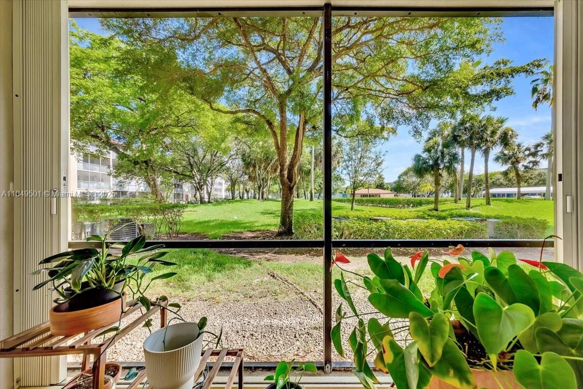 13455 Southwest 16th Court, Unit 104F Pembroke Pines, FL 33027 - Photo 19 of 53 a view of a garden with an outdoor seating