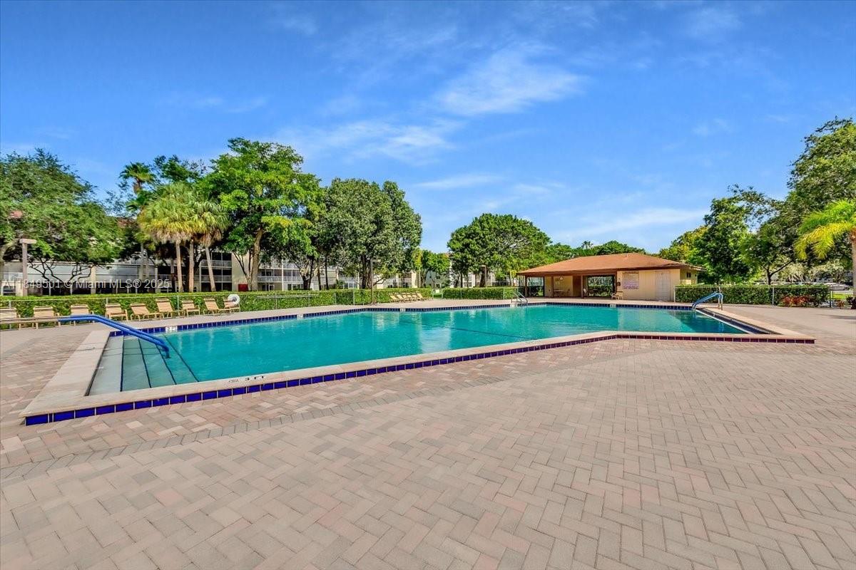 13455 Southwest 16th Court, Unit 104F Pembroke Pines, FL 33027 - Photo 22 of 53 a view of swimming pool with a yard