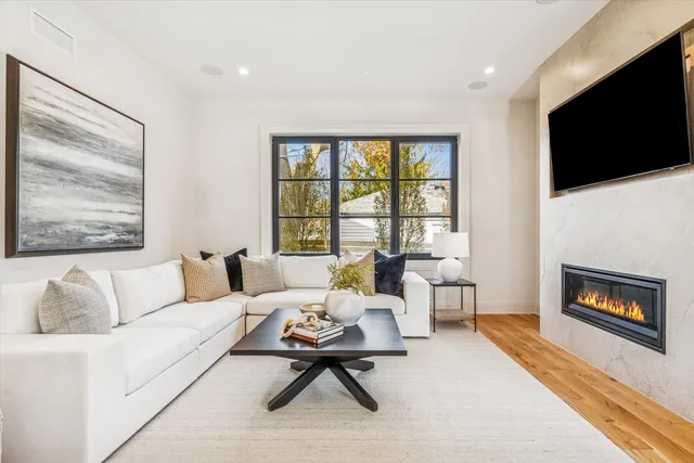 a kitchen with stainless steel appliances granite countertop a stove a sink dishwasher a dining table and chairs with wooden floor