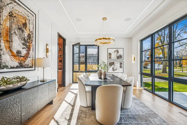 a dining room with furniture a floor to ceiling window and wooden floor