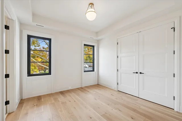 a view of a room with wooden floor and windows