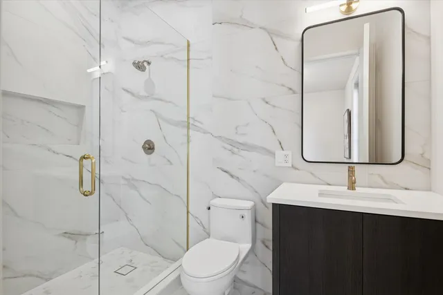 a bathroom with a sink a toilet and shower