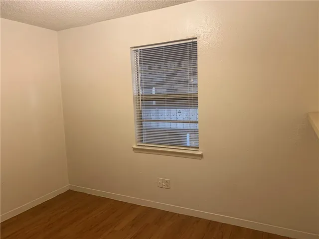 a view of a small space with wooden floor and a window