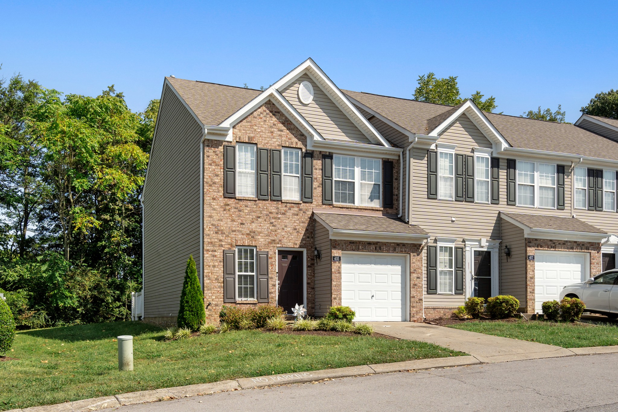 a front view of a house with a yard and trees