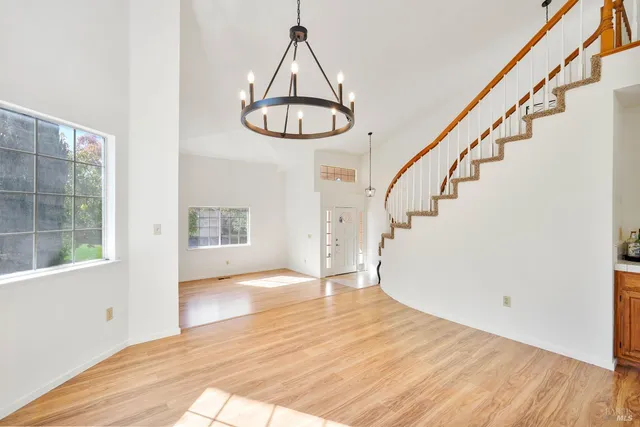 an empty room with windows and ceiling fan