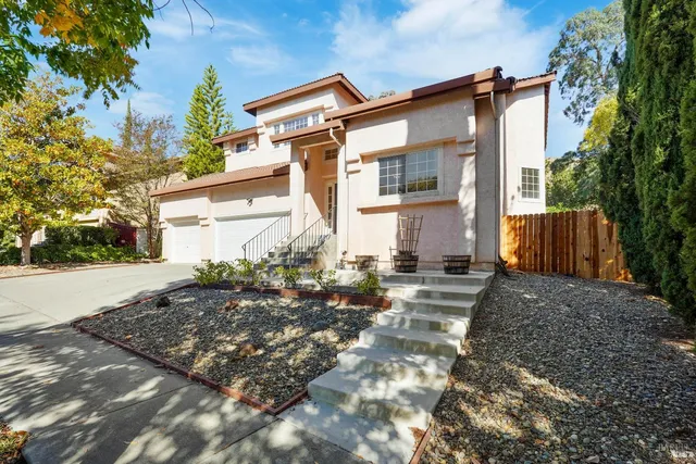 a dining room with furniture a potted plant and wooden floor