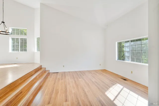 a view of empty room with fireplace and wooden floor