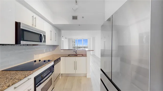 a kitchen with a sink and steel appliances