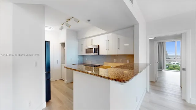a kitchen with stainless steel appliances granite countertop a refrigerator and a sink
