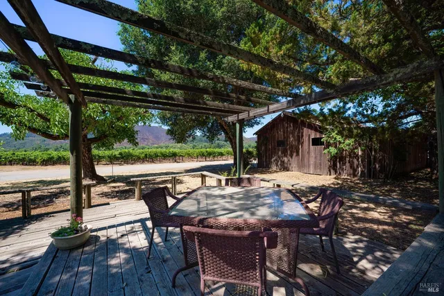 a view of patio with table and chairs a barbeque with a large tree