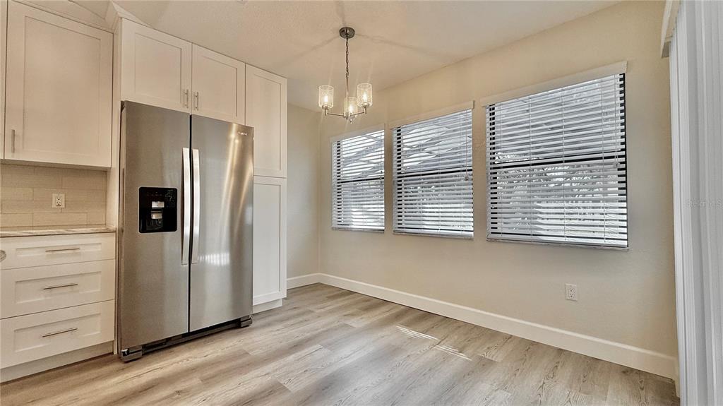 18917 Parade Road Hudson, FL 34667 - Photo 15 of 39 a view of a kitchen with a refrigerator cabinets a ceiling fan and wooden floor