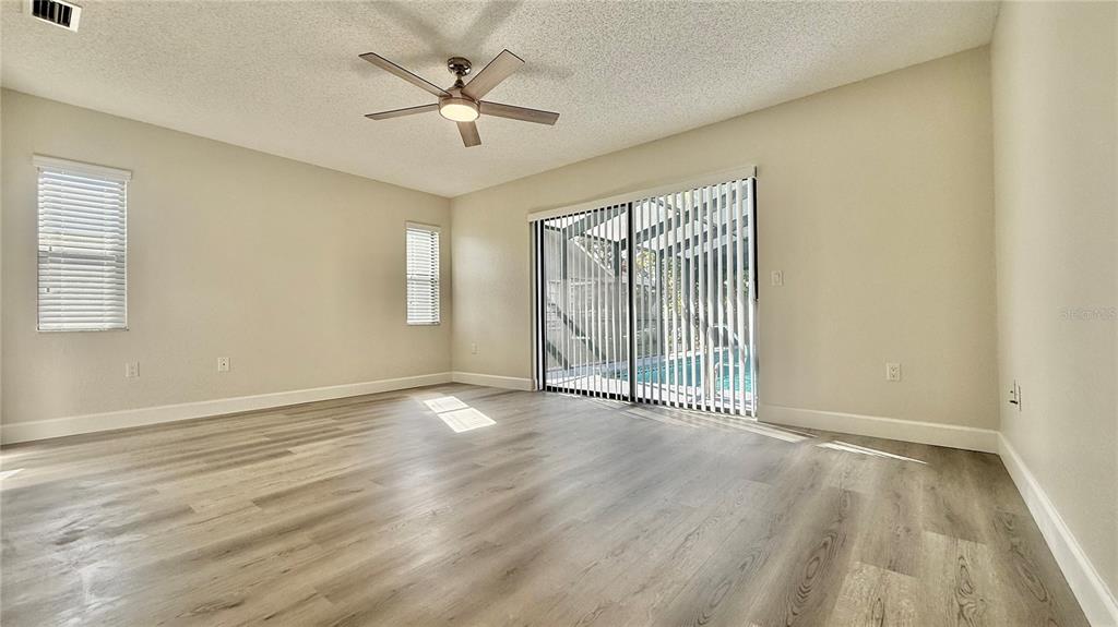 18917 Parade Road Hudson, FL 34667 - Photo 18 of 39 an empty room with wooden floor and windows